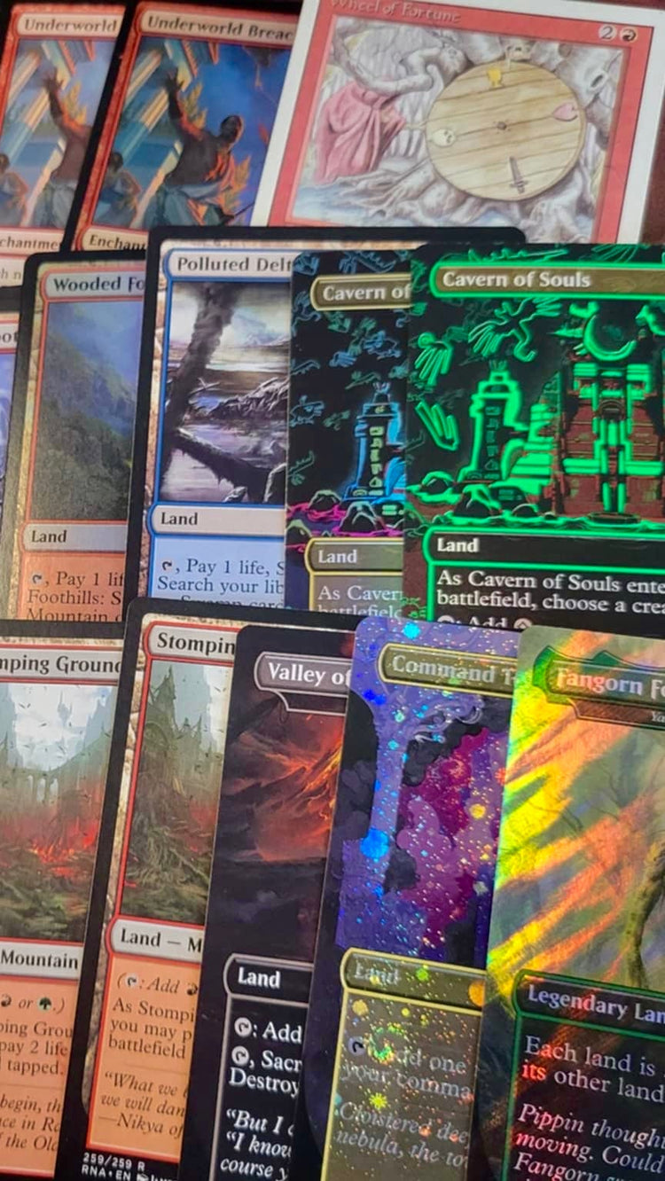 A close-up, top-down view of a collection of Magic: The Gathering trading cards spread out on a surface. The cards feature various colorful art illustrations and holographic finishes, including green, blue, and multicolor holographic effects.