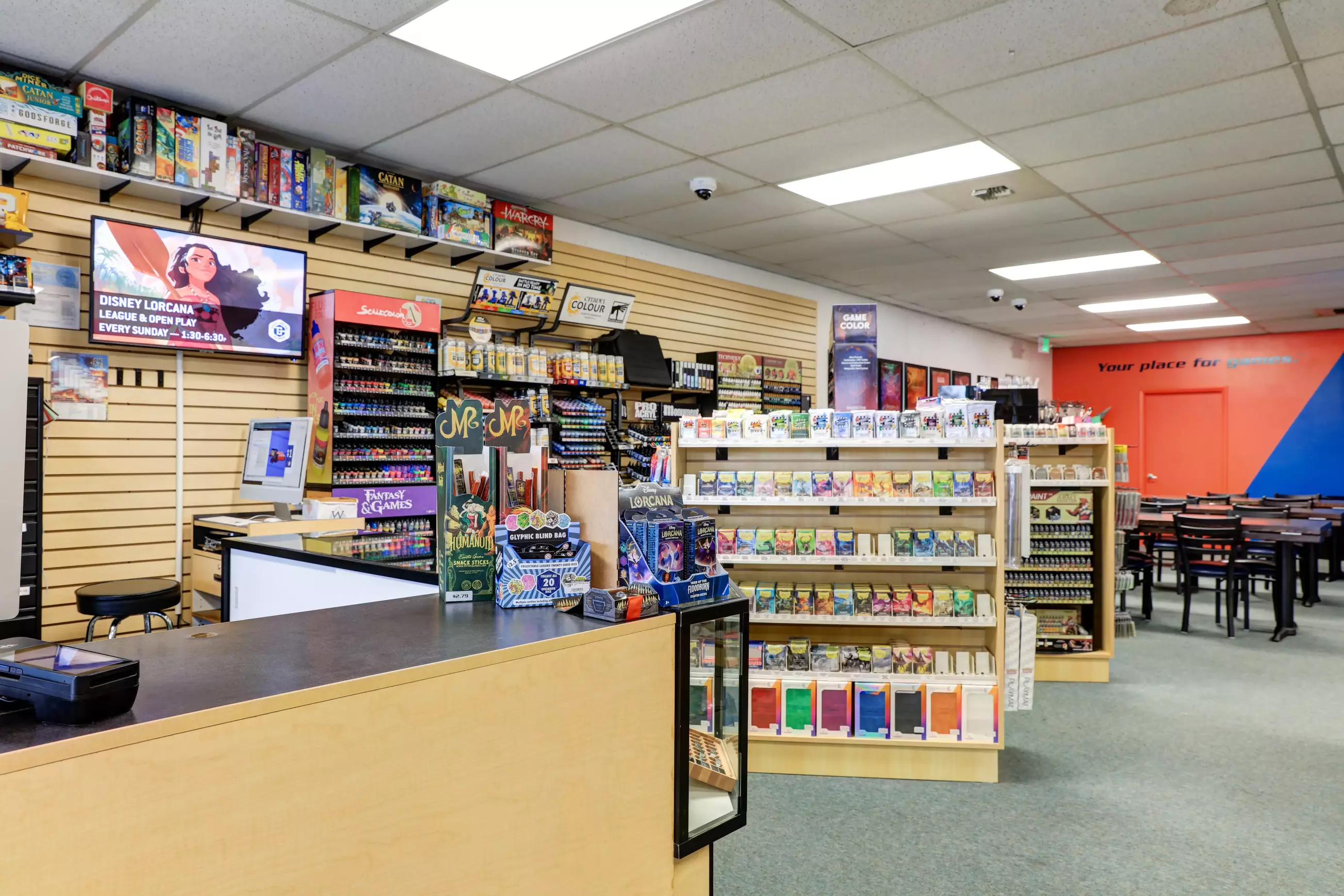 The cash wrap and play space of the store, well-lit, with lots of games.