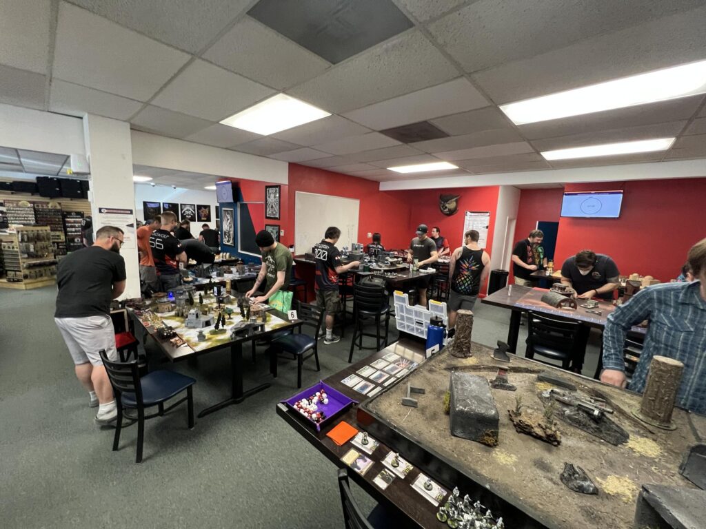 A room full of miniature gamers setting up terrain and playing Star Wars Legion